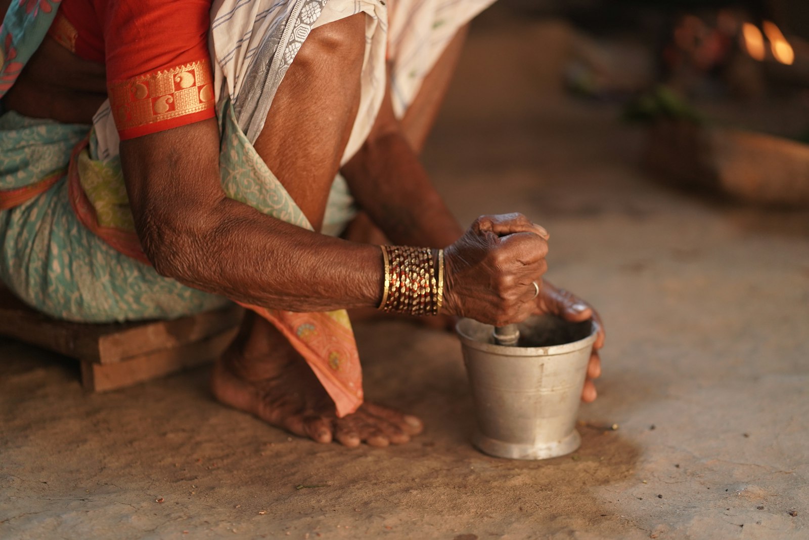 Elderly hands grinding spices with a mortar and pestle